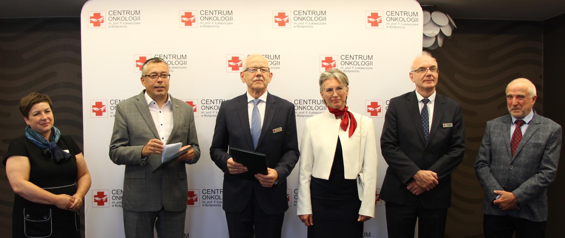 Artur Michalski, zastępca prezesa zarządu NFOŚiGW (drugi od lewej) w siedzibie beneficjenta Centrum Onkologii w Bydgoszczy. Zdjęcie grupowe 6 osób