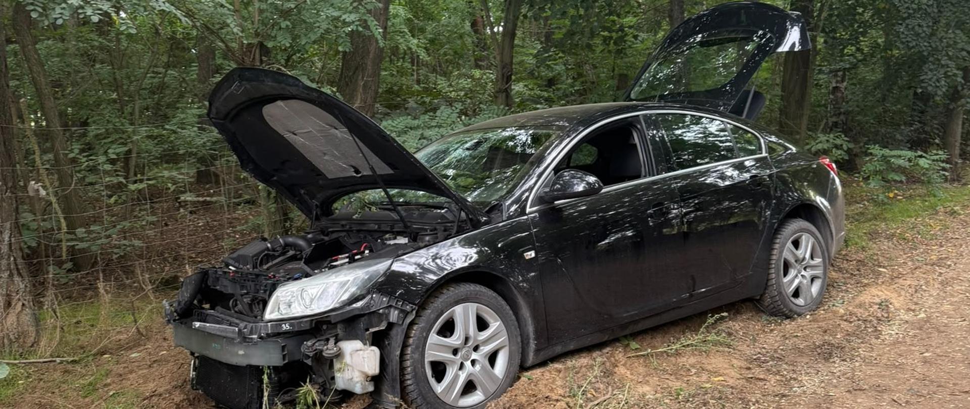 Czarny uszkodzony pojazd na poboczu