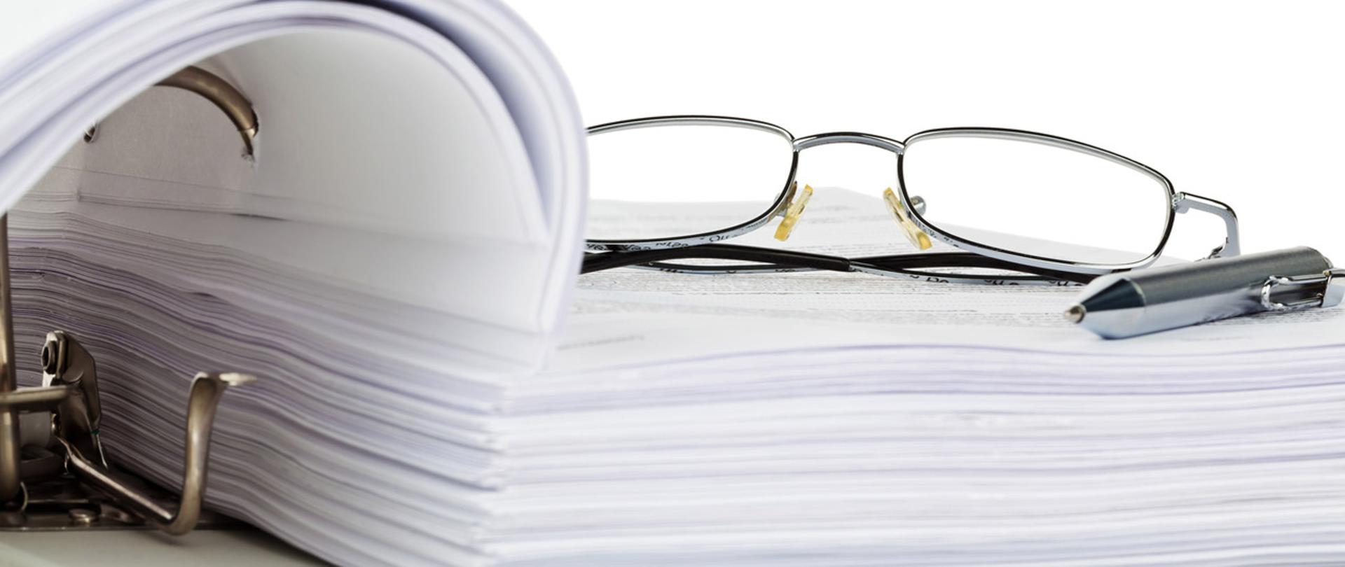 Okulary i długopis na segregatorze