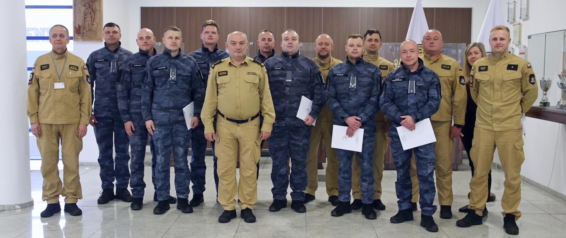Pamiątkowe zdjęcie grupowe funkcjonariuszy Straży Marszałkowskiej będących uczestnikami szkolenia z zakresu gaszenia pożarów wewnętrznych (8 osób) w towarzystwie Komendanta Centralnej Szkoły PSP, kobiety oraz pięciu funkcjonariuszy CS PSP
