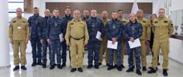 Pamiątkowe zdjęcie grupowe funkcjonariuszy Straży Marszałkowskiej będących uczestnikami szkolenia z zakresu gaszenia pożarów wewnętrznych (8 osób) w towarzystwie Komendanta Centralnej Szkoły PSP, kobiety oraz pięciu funkcjonariuszy CS PSP