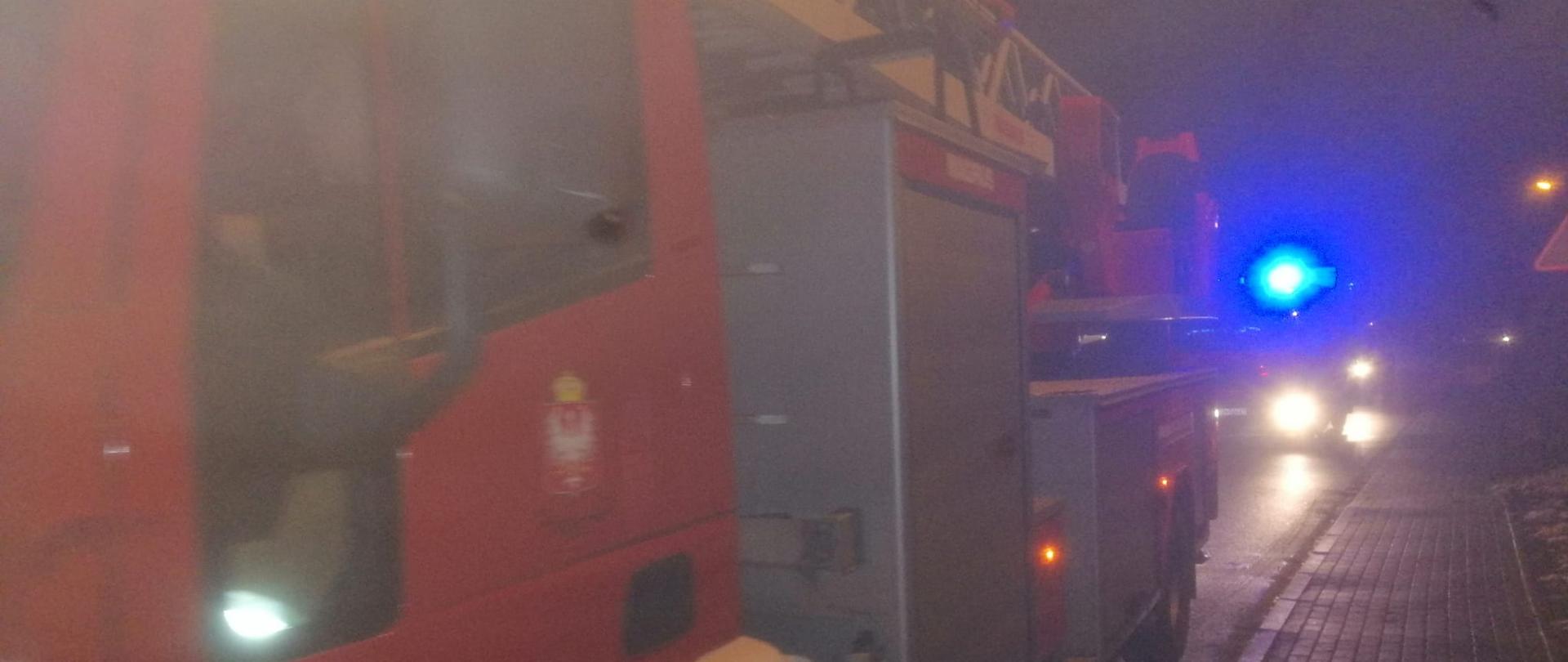 Na zdjęciu widać samochody pożarnicze biorące udział w akcji -jest ciemno