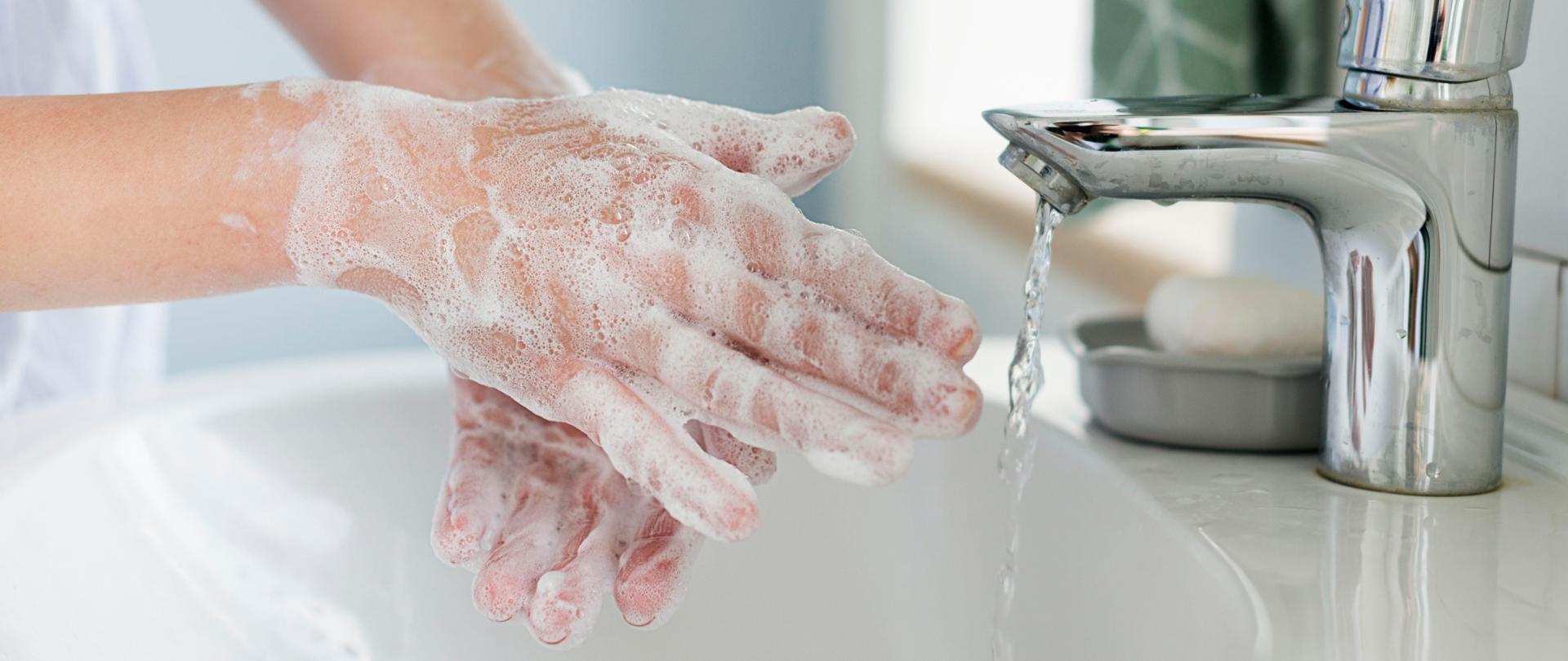 Zdjęcie przedstawia namydlone mydłem ręce.