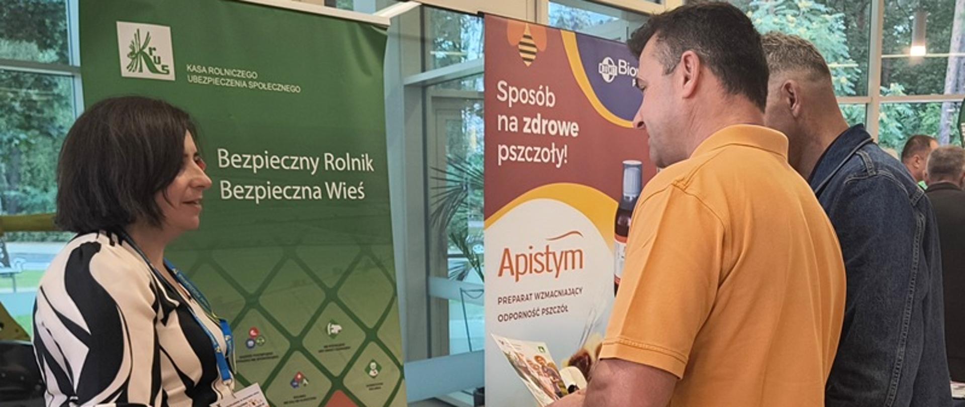 Przy stoisku informacyjno-prewencyjnym Kasy znajduje się grupa osób, od lewej są to: Pracownik PT KRUS w Stalowej Woli - Agata Siembida oraz osoby odwiedzające stoisko. 