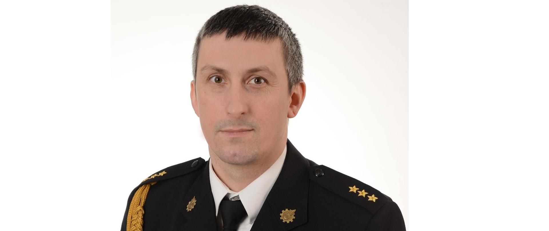 Zdjęcie portretowe Zastępcy Komendanta Powiatowego PSP na jasnym tle w mundurze galowym