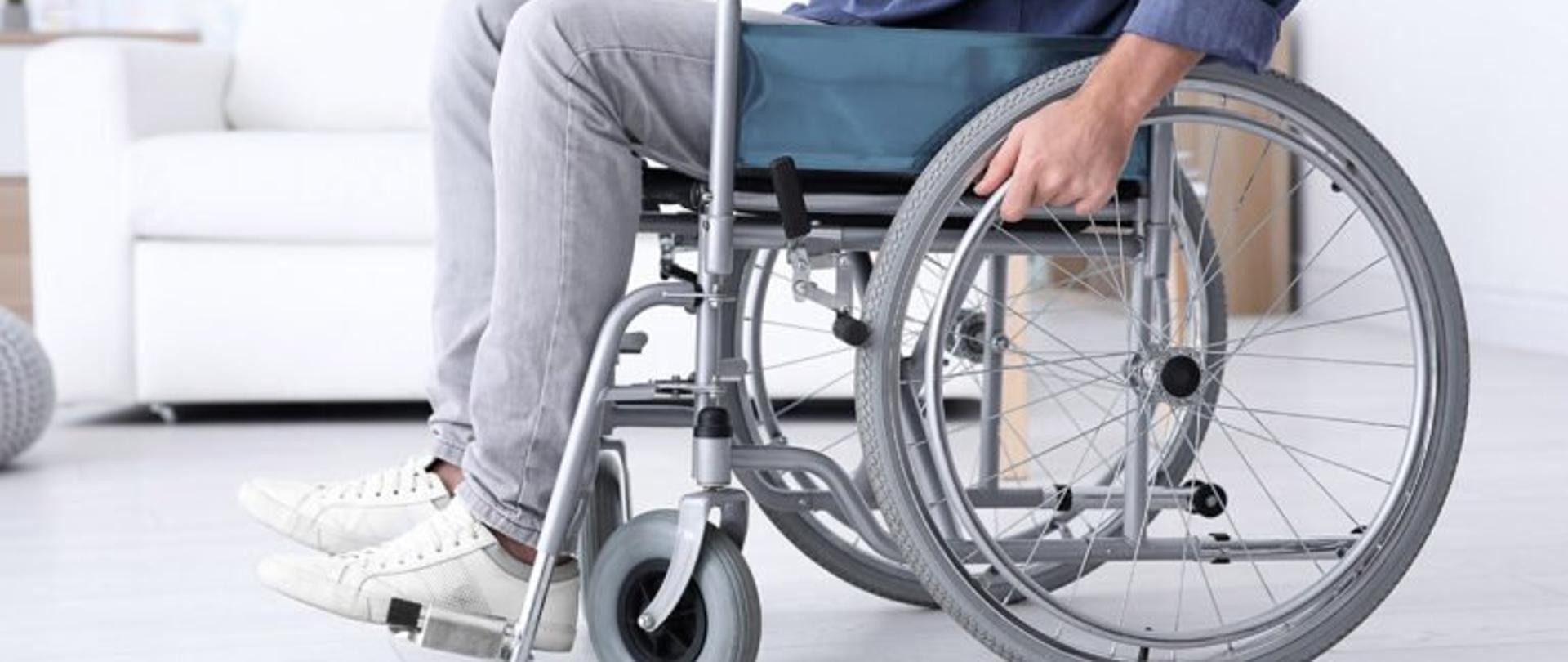 Zdjęcie przedstawia osobę z niepełnosprawnością na wózku inwalidzkim
