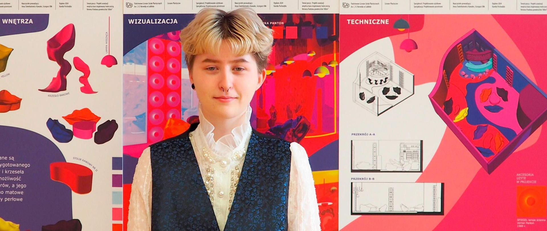 Młoda osoba, za nią na ścianie plansze prezentacyjne