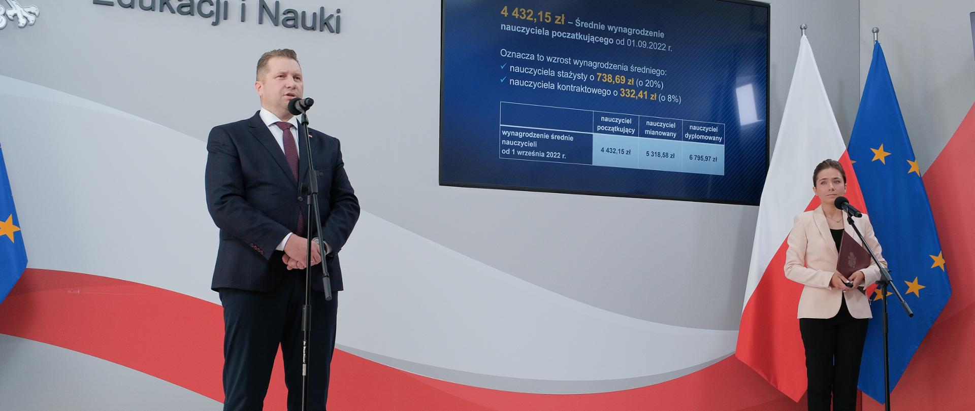 Minister Przemysław Czarnek i rzecznik prasowa ministerstwa Adrianna Całus stoją przed mikrofonami podczas konferencji