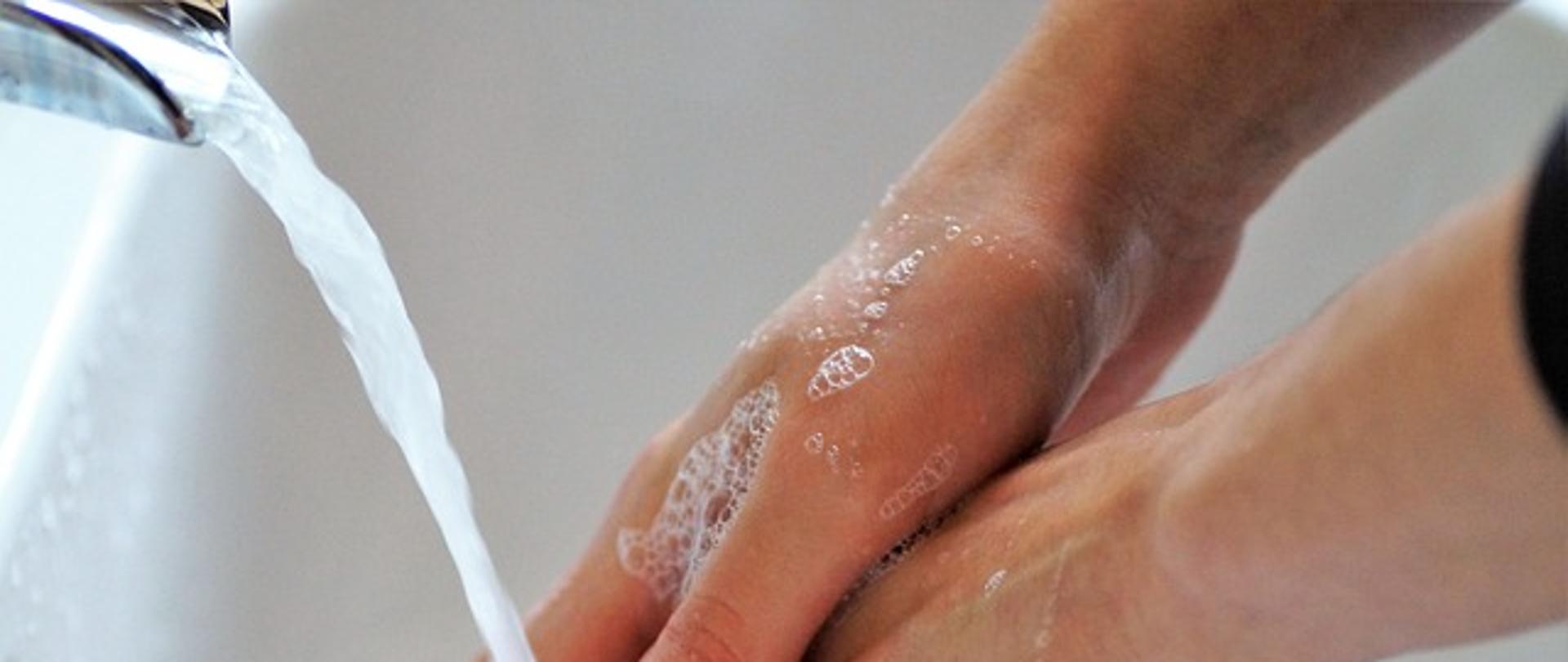 na zdjęciu widzimy osobę myjącą ręce 