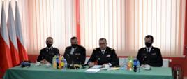 czterech funkcjonariuszy PSP siedzi za stołem podczas konsultacji społecznych projektu ustawy o Ochotniczej Straży Pożarnej w woj. małopolskim 
