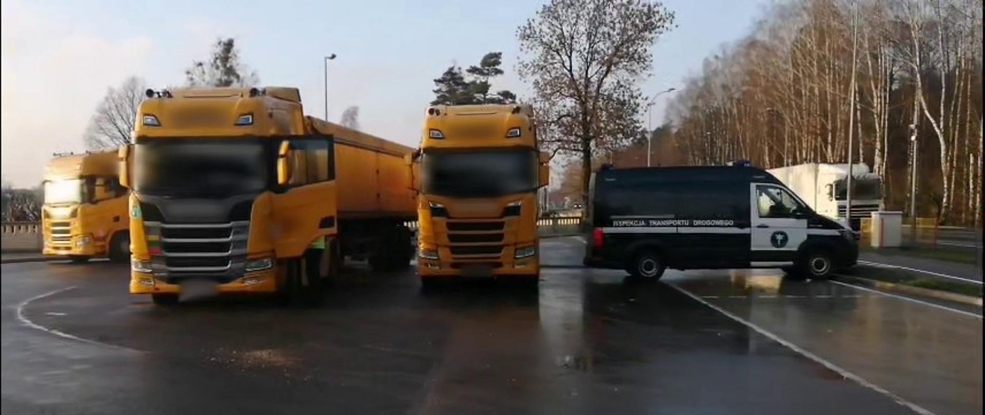 Od lewej: ciągniki siodłowe z podpiętymi naczepami typu wywrotka i oznakowany furgon podlaskiej Inspekcji Transportu Drogowego stoją w punkcie kontrolnym przy krajowej „dziewiętnastce” w Białymstoku.