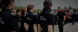 Uczniowie klasy policyjnej stoją na baczność, przed nimi stoi funkcjonariusz Policji.