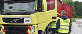 Inspektorzy sprawdzający samochód ciężarowy przewożący odpady