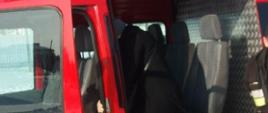 Na zdjęciu widać samochód pożarniczy typu bus do którego wsiada kobieta. Tuż za nią znajduje się strażak.