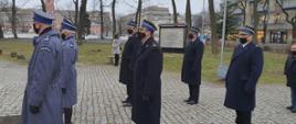 Zdjęcie przedstawia funkcjonariuszy Państwowej Straży Pożarnej oraz Policji w umundurowaniu wyjściowym na placu. Funkcjonariusze stoją w 3 szeregach.