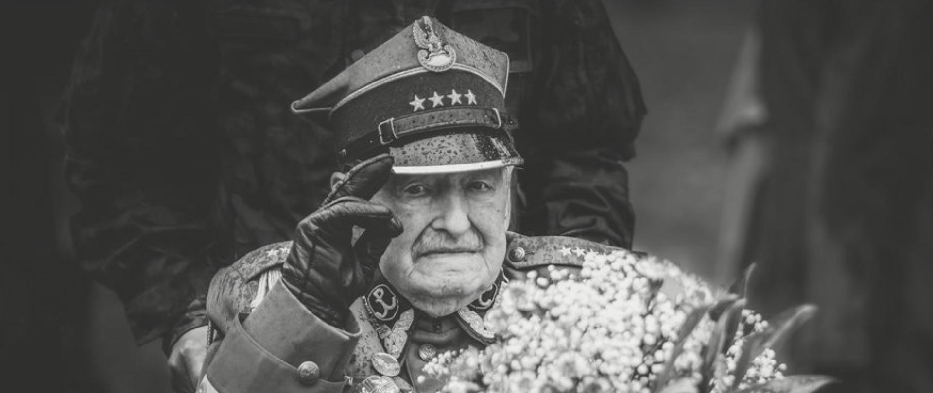 starszy człowiek, żołnierz w mundurze trzyma kwiaty i salutuje