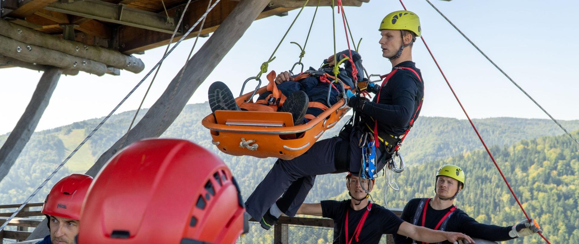 Strażacy ewakuują osobę w noszach wannpwych
