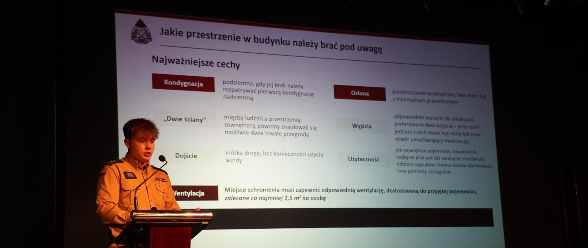 Strażak PSP omawia zasady wyboru odpowiednich miejsc schronienia w budynkach.