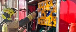 Zdjęcie przedstawia strażaka przy pulpicie sterowniczym motopompy