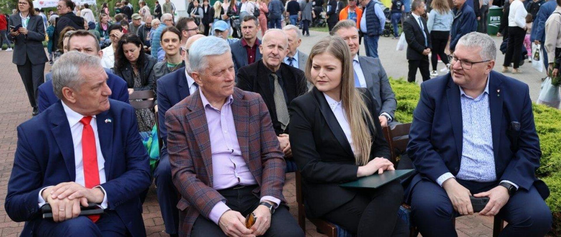 Na placu, na ustawionych w rzędach krzesłach siędza uczestnicy otwarcia targów marszewskich