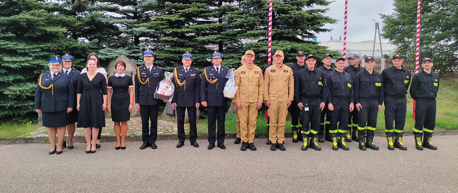 Pracownicy i funkcjonariusze komendy ustawieni w szeregu pozują do zdjęcia 