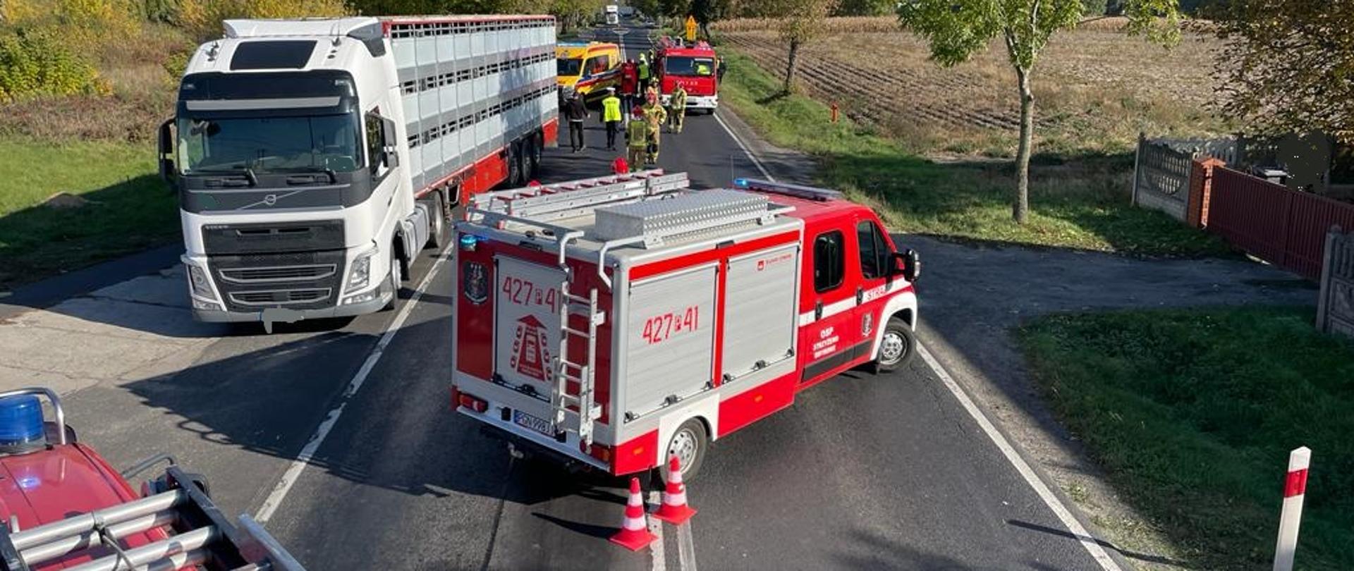 Zdjęcie zrobione z dachu samochodu pożarniczego. Widać na nim inne samochody pożarnicze, karetkę pogotowia oraz samochód ciężarowy biorący udział w zdarzeniu
