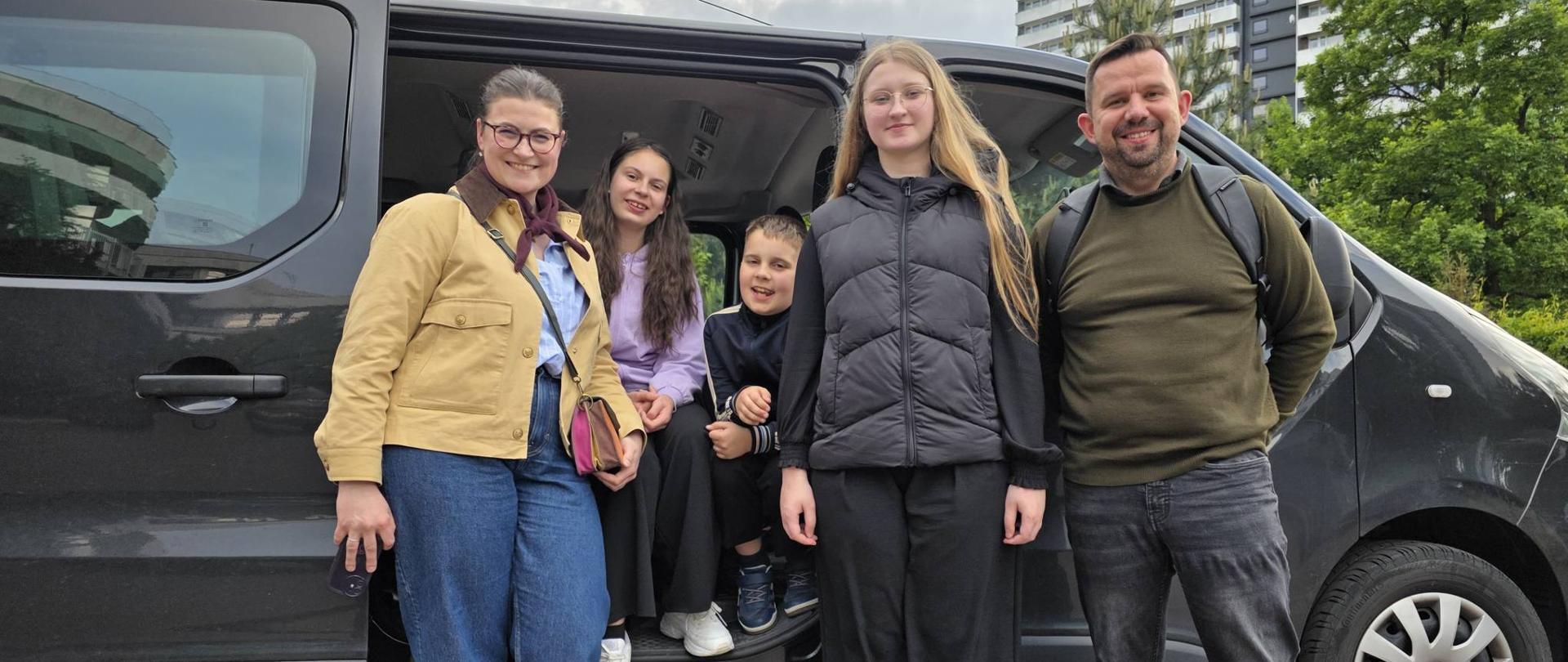 Kontrabasiści z naszej szkoły wraz z nauczycielem i akompaniatorem przed samochodem szkolnym na parkingu tuż po zakończeniu konkursu kontrabasowego w Katowicach