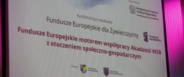 Fundusze Europejskie na Akademii Wyższej Szkoły Biznesu w Żywcu, telebim informujący o konferencji naukowej poświęconej Funduszom Europejskim na Żywiecczyźnie