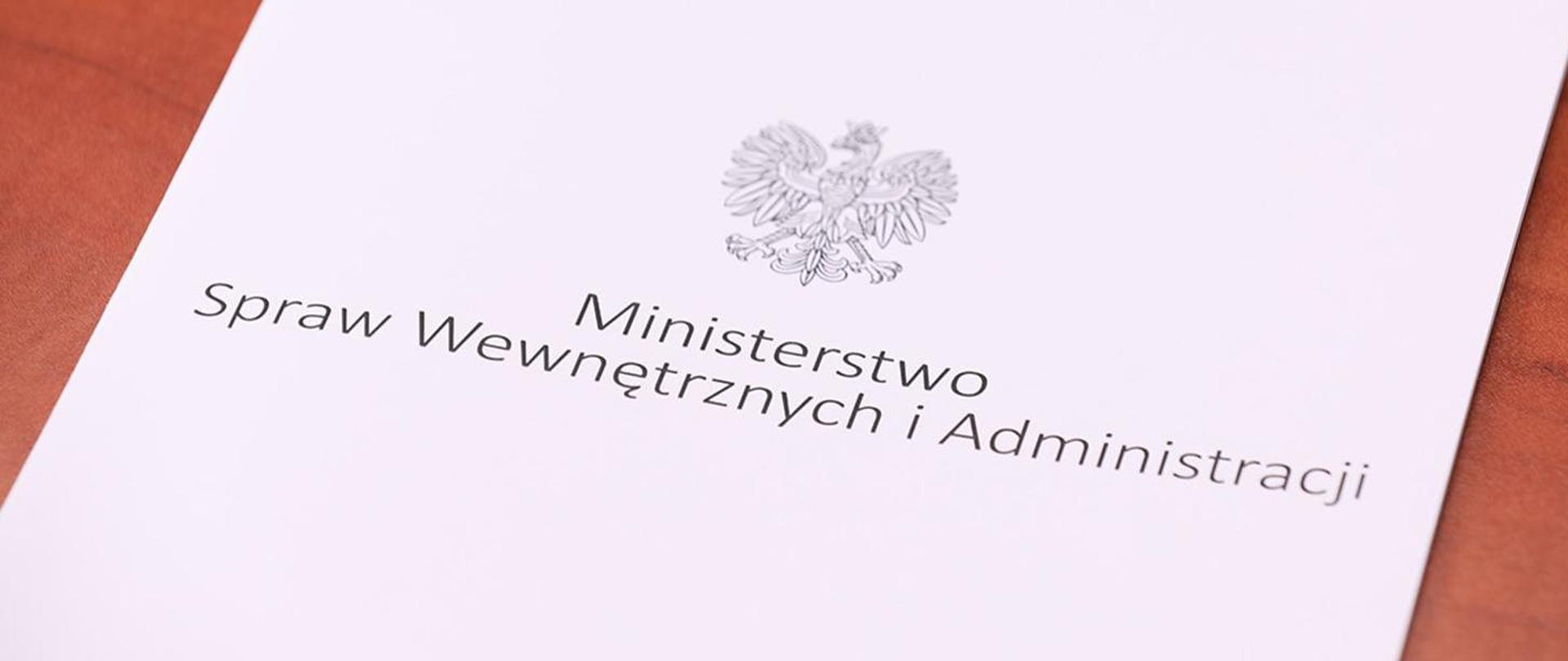 Zdjęcie przedstawia teczkę z orłem, a poniżej znajduje się napis Ministerstwo Spraw Wewnętrznych i Administracji