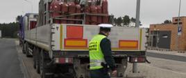 Inspektor lubuskiej Inspekcji Transportu Drogowego kontroluje ciężarówkę przewożącą towary niebezpieczne (ADR).