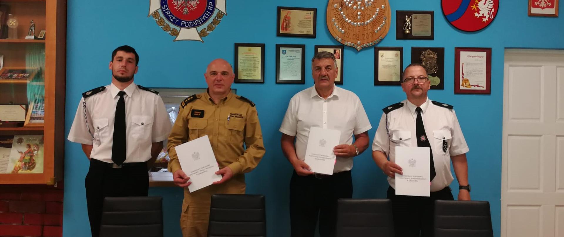 Zdjęcie ukazuje komendanta powiatowego PSP w Limanowej, Prezesa i naczelnik OSP Lubomierz oraz Wojta gminy Mszana Dolna trzymających akt porozumienia