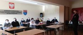 Na świetlicy komendy powiatowej PSP w Krotoszynie, komendant powiatowy wita zaproszonych gości. Spotkanie zostało zorganizowane celem omówienia rozporządzenia dotyczącego świadczenia ratowniczego dla ratowników OSP. Uczestnicy w osobach przedstawicieli samorządów terytorialnych oraz komendantów miejsko - gminnych Z OSP RP zachowują zasady reżimu sanitarnego korzystając z maseczek ochronnych, 