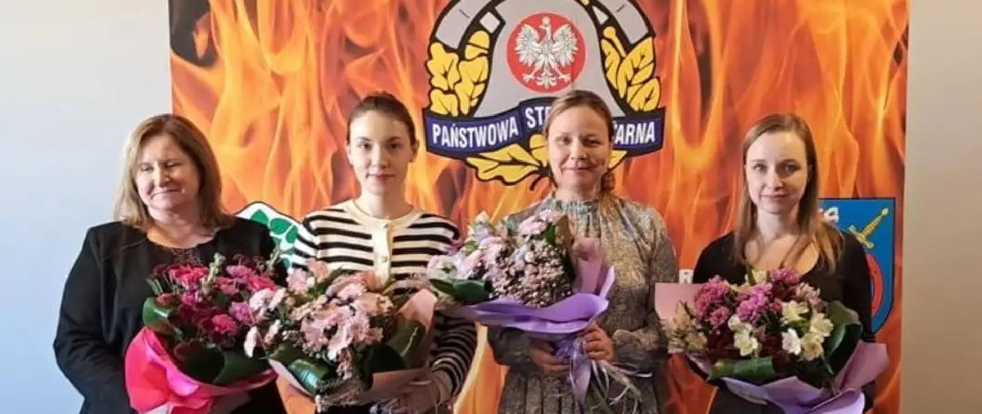 Na zdjęciu cztery kobiety z bukietami w rękach. Pracownice KP PSP Braniewo.