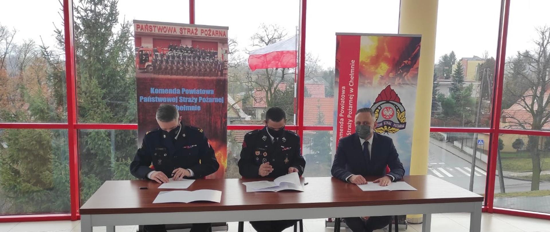 Na sali sztabowej Komendy Powiatowej PSP w Chełmnie znajdują się Komendant Powiatowy PSP, Wójt Gminy Kijewo Królewskie oraz Prezes OSP Trzebcz Szlachecki.