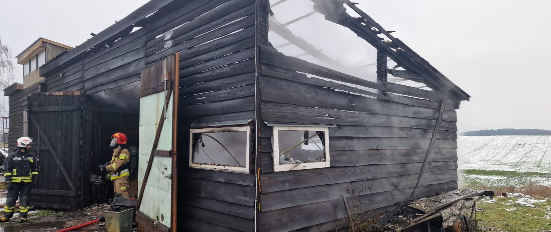 widać spaloną część budynku i strażaków po działaniach