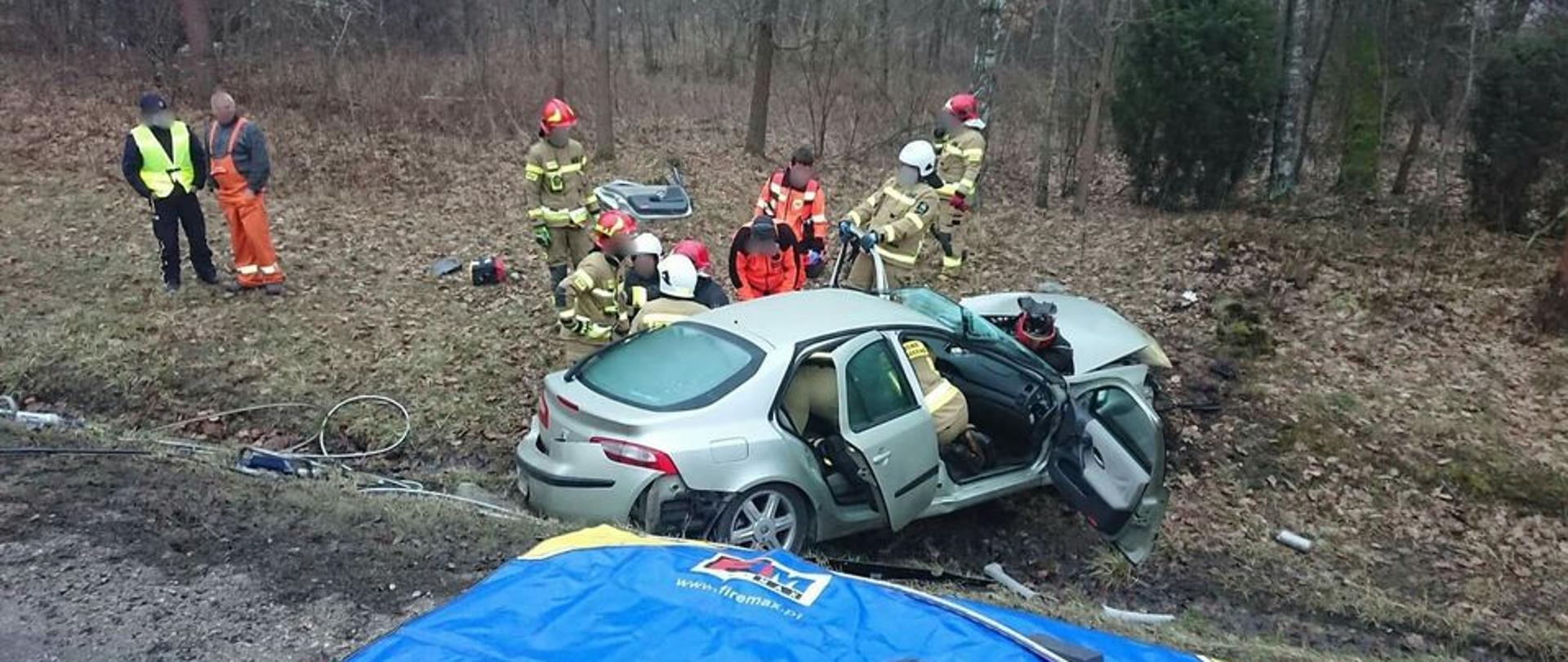 Strażacy prowadzą działania ratownicze we wraku samochodu osobowego w którym zakleszczony jest kierowca