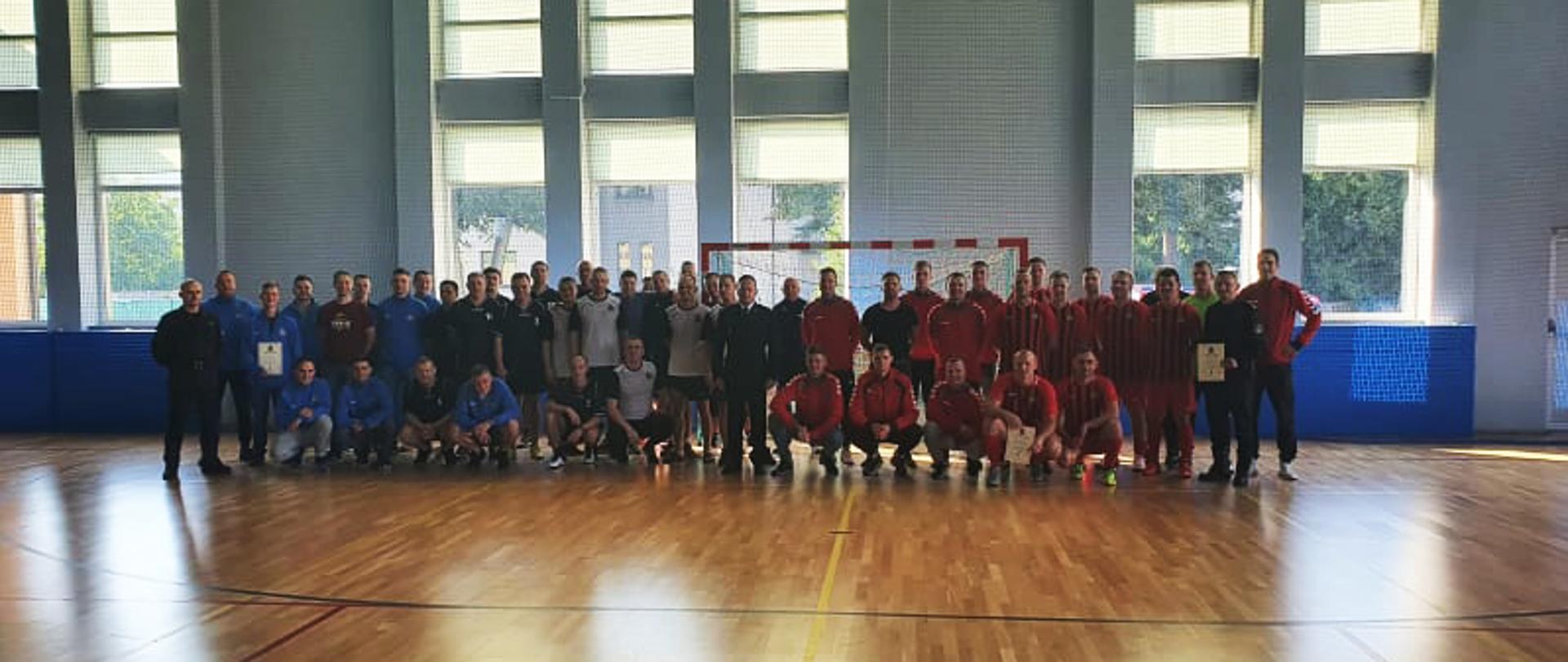 Drużyny stoją przed bramką na boisku.