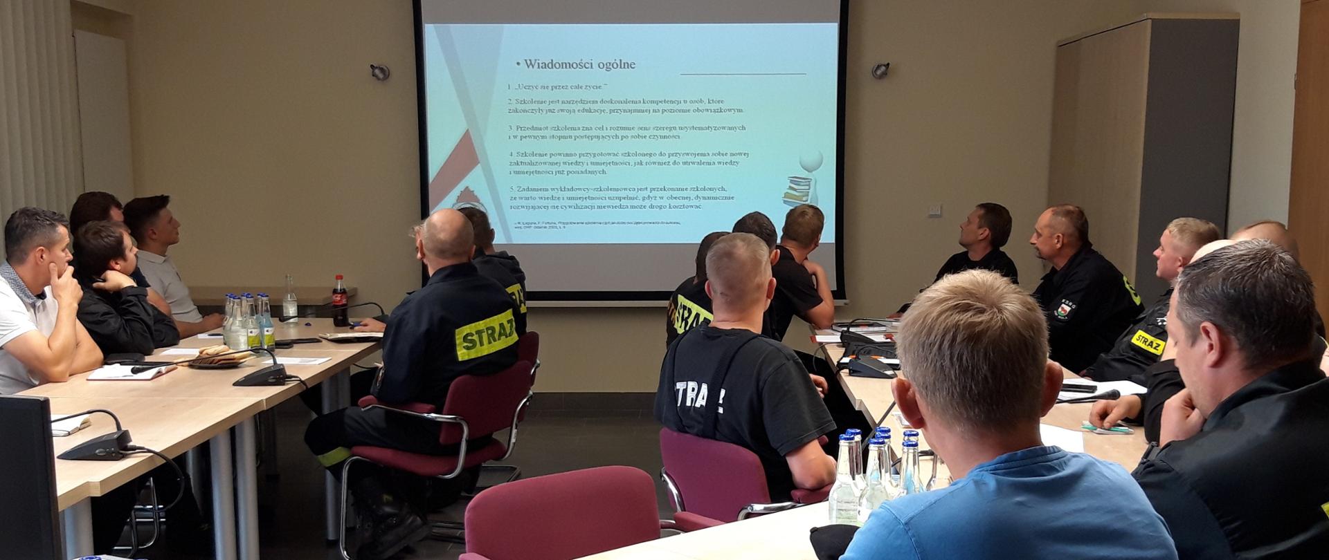 Druhowie OSP podczas szkolenia na sali sztabowej Komendy Miejskiej z zakresu bezpieczeństwa i higieny pracy