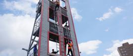 Zawodnicy wspinający się na 3 piętro wspinalni przy użyciu drabiny hakowej