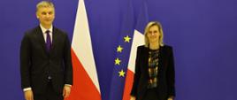 Minister rozwoju i technologii Piotr Nowak stoi na tle flag Polski, UE i Francji, po jego prawej stronie stoi francuska minister ds. przemysłu Agnès Pannier-Runacher 