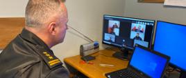 Wideokonferencja - Akcja Zima 2021 - na zdjęciu zastępca kujawsko-pomorskiego komendanta wojewódzkiego st. bryg. Robert Wiśniewski w trakcie zdalnego spotkania Sztabu kryzysowego. Tematem omawianym są warunki zimowe w regionie. Komendant w umundurowaniu dowódczo-sztabowym. Na monitorze widoczni rozmówcy - członkowie Sztabu.