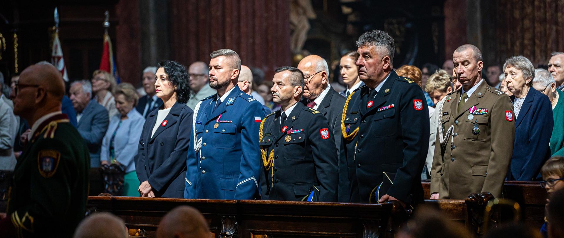 Mundurowi znajdują się w ławie kościelnej podczas mszy.