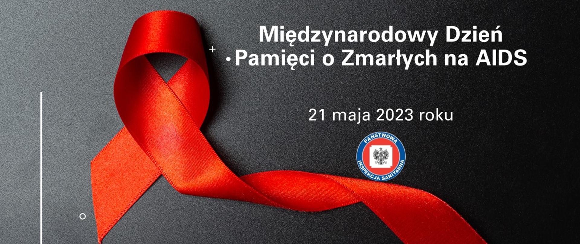 Czerwona wstążka na czarnym tle biały napis Światowy Dzień Pamięci o zmarłych na AIDS