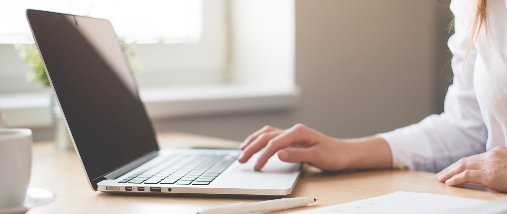 dłonie kobiety na klawiaturze laptopa