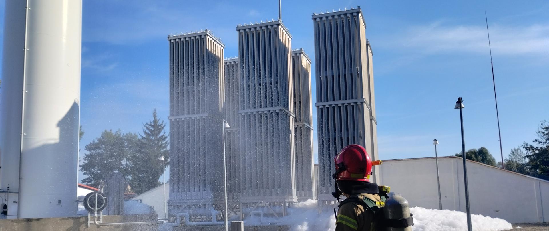 Zdjęcie przedstawia strażaka w ubraniu specjalnym oraz sprzęcie ochrony układu oddechowego, w tlen stacja regazyfikacji