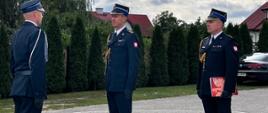 Zdjęcie przedstawia druha podczas składania meldunku komendantowi na placu OSP w Paprotni.