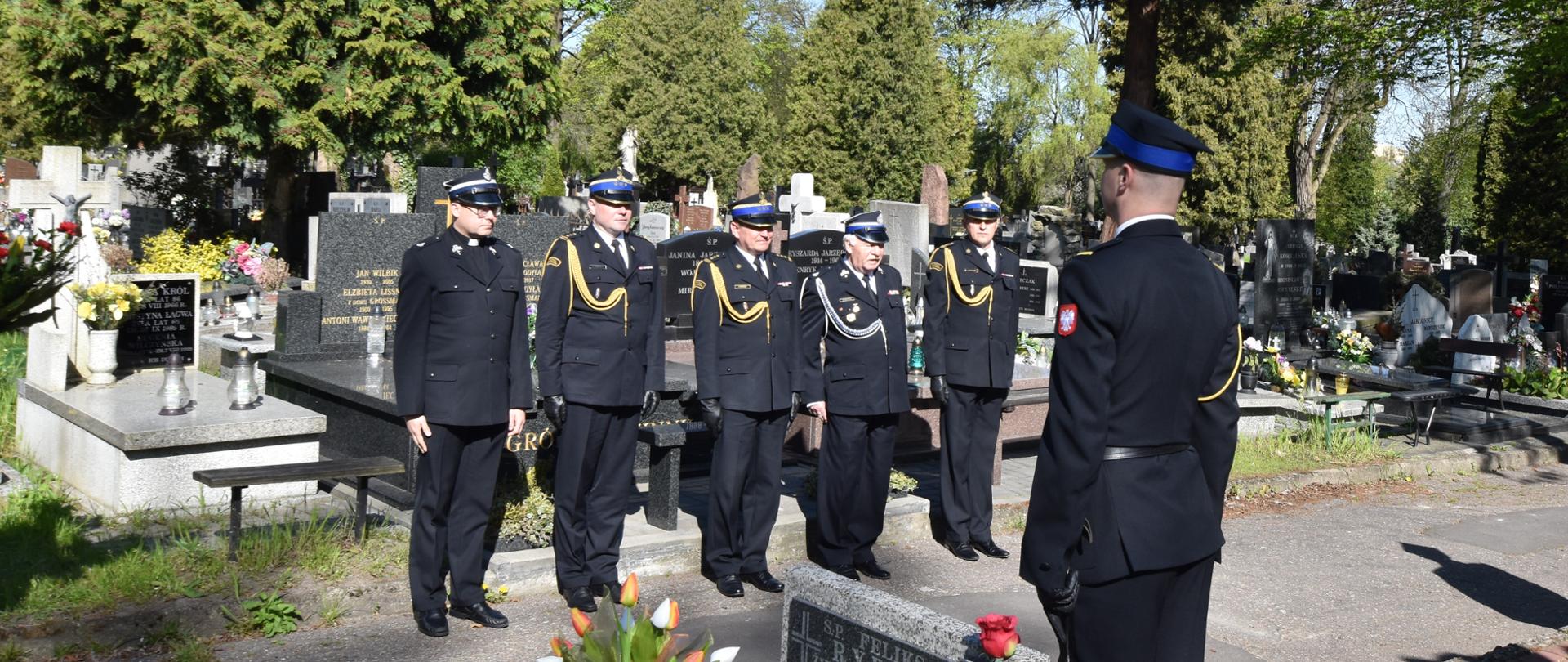 Kierownictwo km psp w łodzi oraz zastępca komendanta wojewódzkiego PSP w Łodzi stojący na baczność przed pomnikiem oddają hołd poległym strażakom