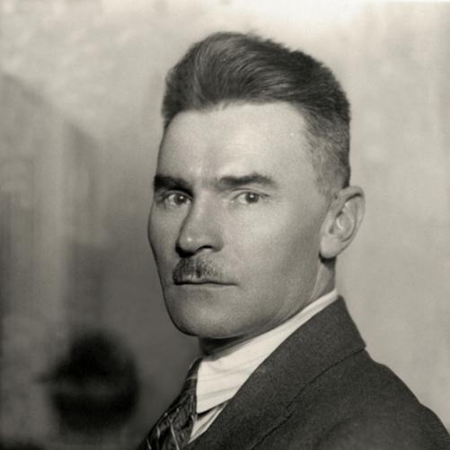 Jan Dąbski - Czarno-biały portret mężczyzny, półprofil, ciemne włosy, drobne wąsy, ciemna marynarka, biała koszula i ciemny krawat.