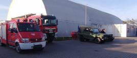 Dwa samochody ratowniczo-gaśnicze widoczne na parkingu.