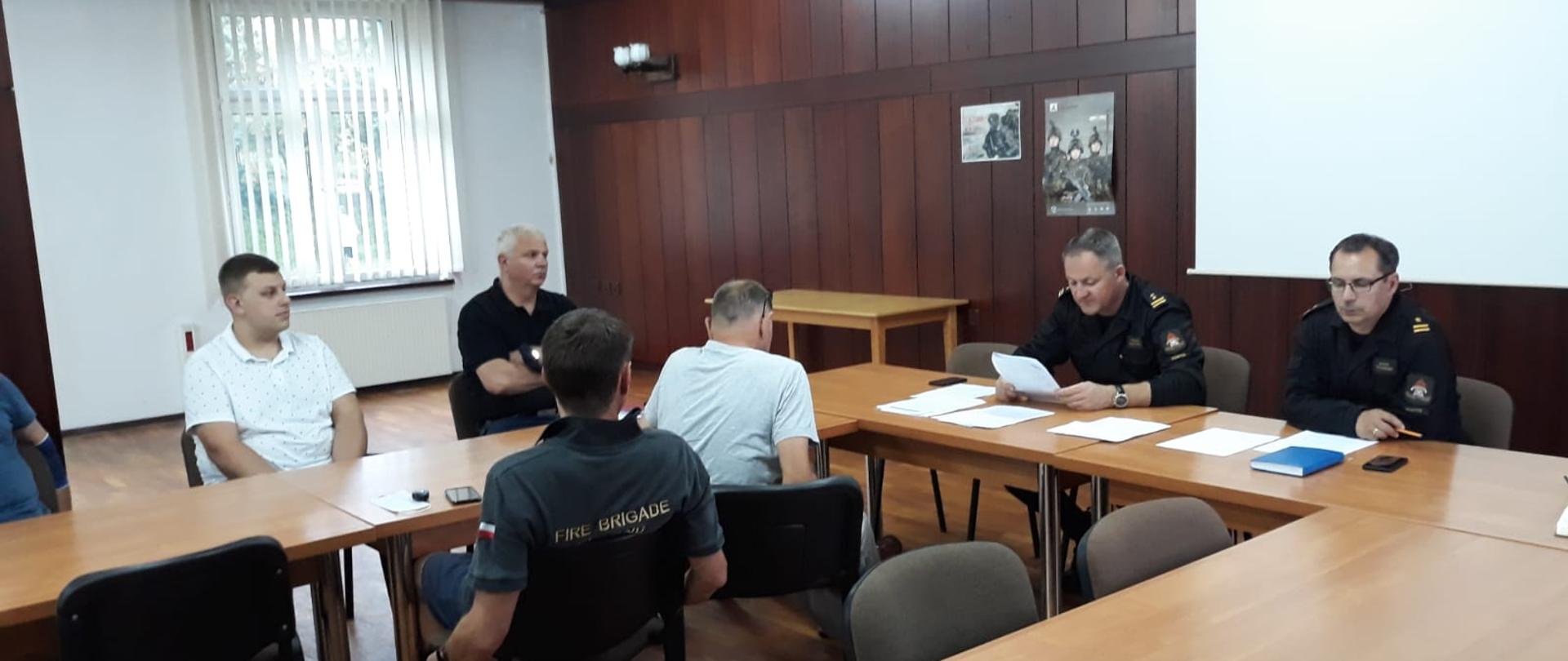 Zdjęcie przedstawia siedzących uczestników spotkania w sprawie programu #Szczepimy się z OSP